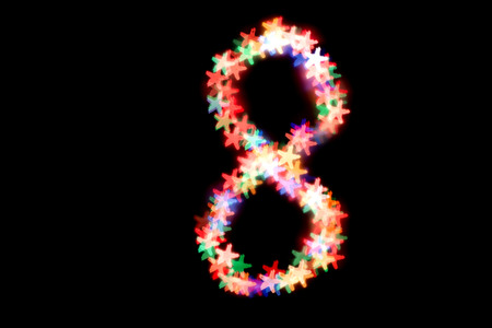 created figure 8 from a colorful bokeh on a black background.International women's day.March 8.の写真素材