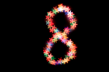 created figure 8 from a colorful bokeh on a black background.International women's day.March 8.の写真素材