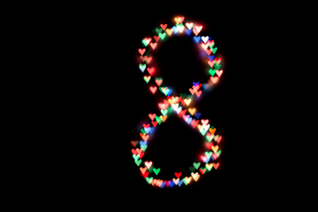 created figure 8 from a colorful bokeh on a black background.International women's day.March 8.の写真素材