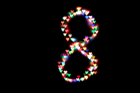 created figure 8 from a colorful bokeh on a black background.International women's day.March 8.の写真素材