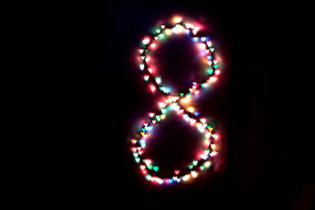created figure 8 from a colorful bokeh on a black background.International women's day.March 8.の写真素材