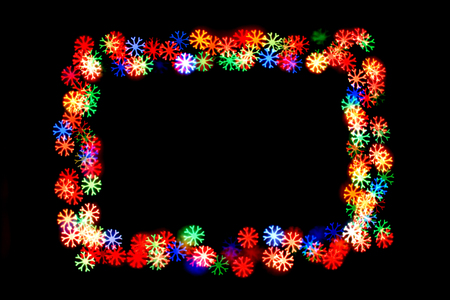 colorful snowflakes form a frame.bokeh snowflakes isolated on black background.frame of snowflakes.の写真素材