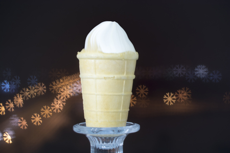 waffle Cup with ice cream on the background of colorful bokeh of snowflakes.の写真素材