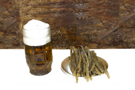 on a white background, there are sliced fish strips and a beer mug with beer and foam.の写真素材
