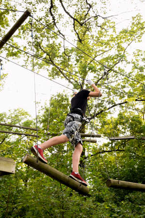 The guy goes through the obstacle course on the rope park