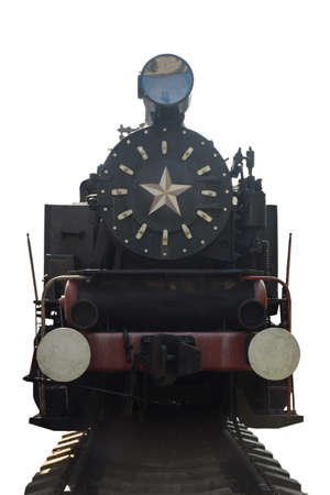 An old steam locomotive stands in front of the bright sun on rails on a clean white background with clipping. Photographed from the frontの写真素材
