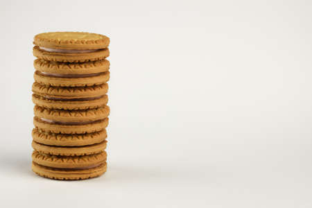 On the left of the frame, a stack of cookies is photographed against a clean white clipping...
