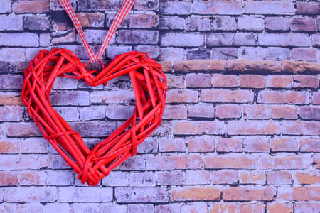Against the background of a brick wall on the left side there is a decorative red heart. On the right there is a place for the inscription on the Valentines Dayの写真素材