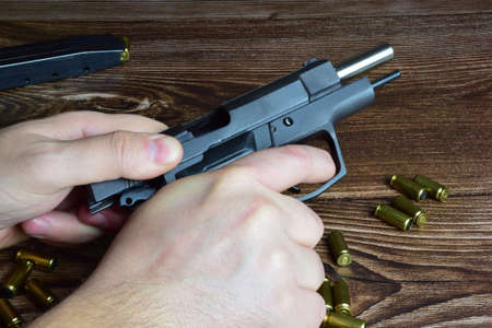 There are a lot of scattered cartridges on a wooden background, as well as a hand twitching the...