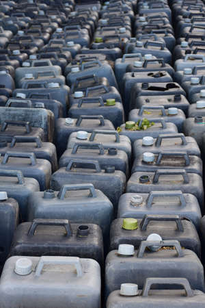 The entire frame is filled with rows of old plastic canisters, closed and open.