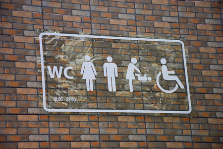 There is a sign on the brick wall with symbolic different symbols for the designation of the toiletの写真素材
