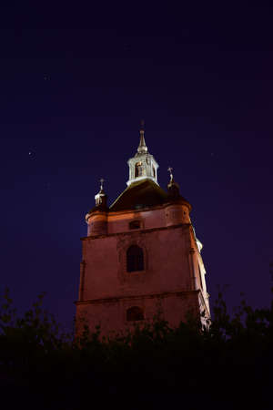 Medieval monastery or church building against the background of the night sky. The building is well lit and stands out in contrastの写真素材