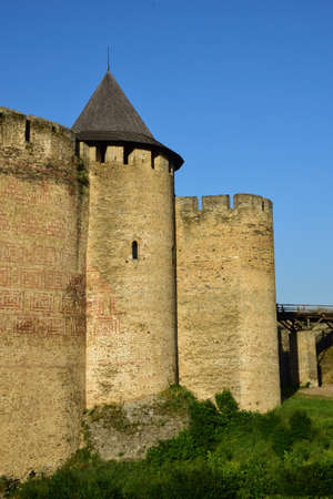 Part of the old stone wall of a medieval fortress with battlements and battlements. On the right...