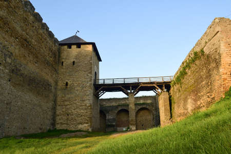 Wooden bridge to the tower of a medieval stone fortress with high battlements and loopholes. View...