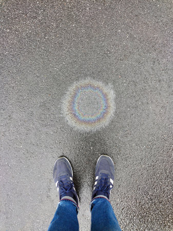 Abstract background with an oil stain of petroleum products on the pavement, a stain of gasoline...