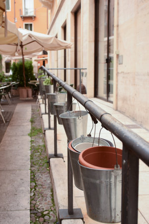 A row of hanging buckets in an open-air cafe in perspective as a decorationの写真素材