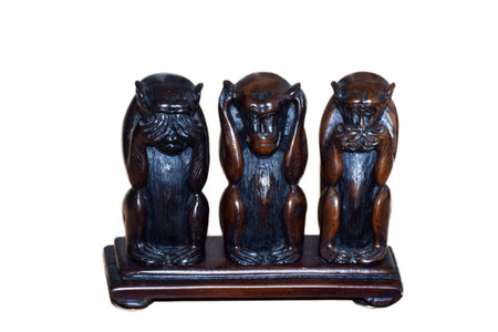 Figurine of three monkeys on a stand with emotions: I hear nothing, I see nothing, I say nothing, on isolated white background, concept photoの写真素材