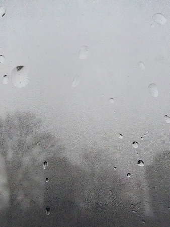 Concept of raindrops falling on a gray background. Abstract wet white surface with bubbles on the...