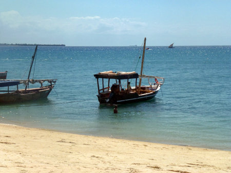 An old traditional fishing boat with a roof is parked near the shore. Sandy beach and pitiful sea...