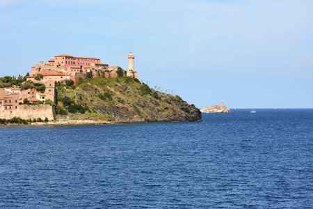 On the Mediterranean coast of Italy, picturesque ancient buildings and an old lighthouse on the background of the sea. Seascapes of Europeの写真素材