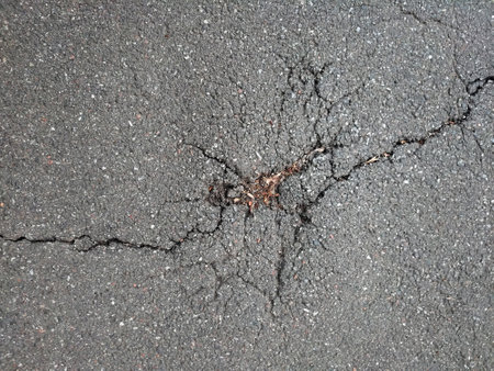 A crack on the asphalt surface of the road on the whole background. View from aboveの写真素材