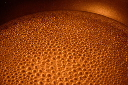 Close-up of many bubbles on foamy amber drink on full backgroundの写真素材