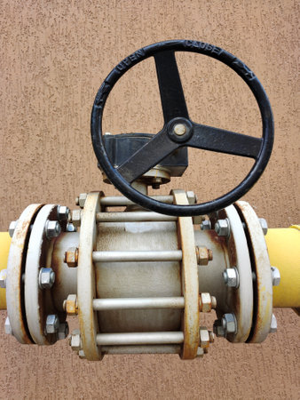 A gas pipe is fastened with many bolts and with a valve close-up. Heavy industry and the energy...
