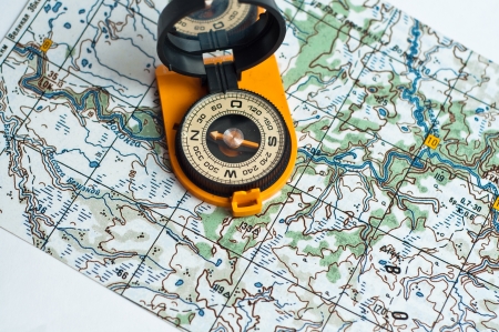 Compass in the orange casing and with the mirror cover is on the topographic map 