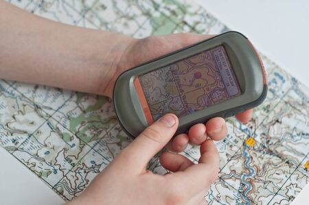 The Navigator to include one screen in a child's hand on the background of a topographical map.