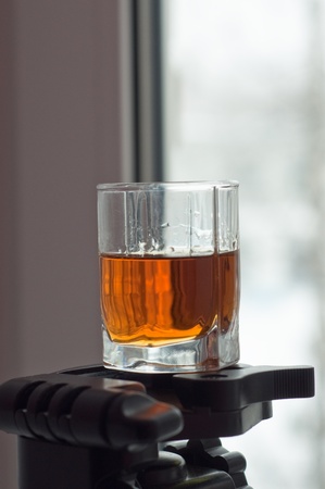 A warming drink pleases snow in the spring. A glass of cognac at the background of the window.の写真素材