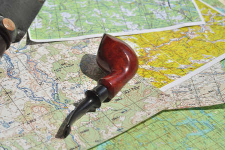 Map and Smoking pipe  The indispensable accessories for travel and adventure 