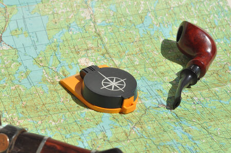 Map, compass and pipe Smoking area. The indispensable accessories for travel and adventure.の写真素材