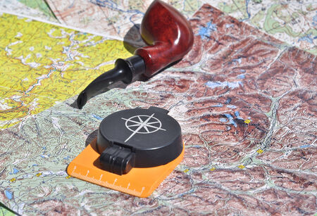 Map, compass and pipe Smoking area. The indispensable accessories for travel and adventure.の写真素材
