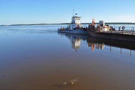 Ferry on the big river. Yakut rivers Lena and Aldan not have bridges. People are waiting for the ferry.の写真素材