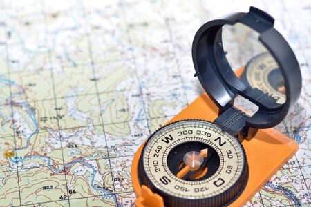 Compass & map - friends travelers. Magnetic compass on a topographic map.の写真素材