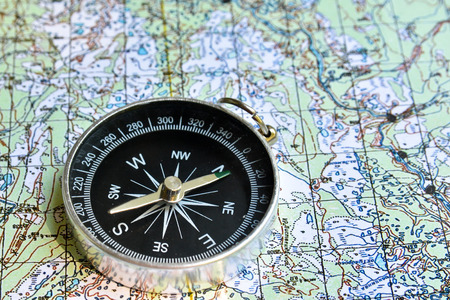 Travel and adventure! The magnetic compass lies on a topographic map.