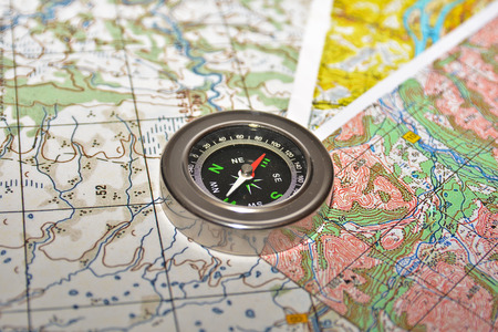 On a few maps is the magnetic compass. Compass laying on a topographic map.の写真素材