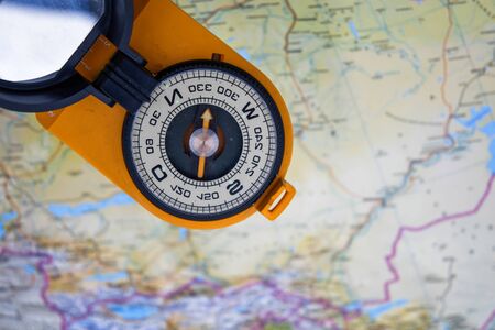 Magnetic compass and map. Tools that help you not to get lost on the ground.の写真素材