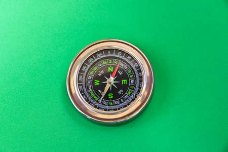 Compass on a green background. Magnetic compass, a tool for navigation.の写真素材