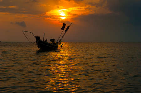 Sea boat art photography. Sunset sun with dramatic cloudsの写真素材