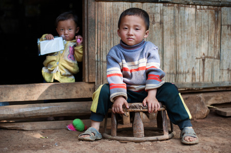 LUANG PRABANG, LAOS - 9 DEC, 2014: Unidentified two kids in traditional village of Laos. Eco tourism is popular tourist attraction in Asiaのeditorial素材