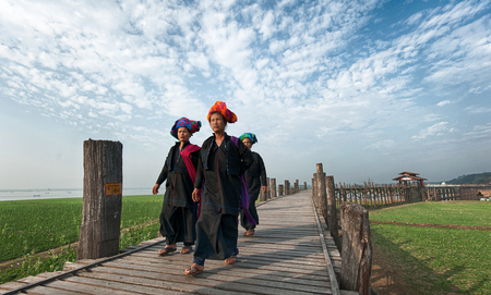 MANDALAY, MYANMAR - JAN 19, 2014  Unidentified Burmese women in traditional clothes visiting U Bein bridge and local Buddhist temple  Domestic tourism is important part of life for people of Myanmarのeditorial素材