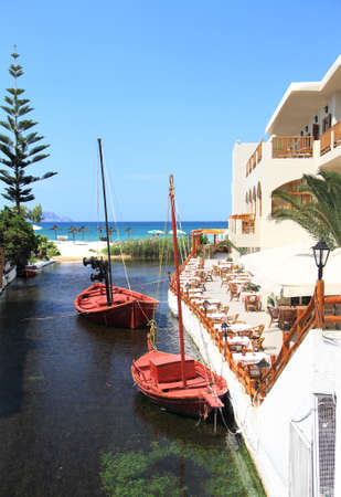 Two fishing boats in the river flows into the sea in Crete