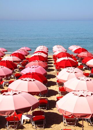 Red umbrellas and deckchairs waiting for the touristsの写真素材