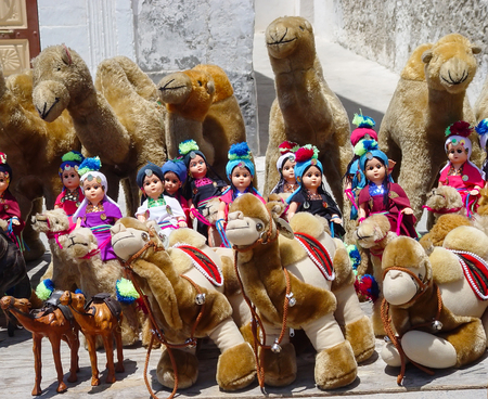 Puppet riders in turbans on a plush camel. Children's soft toys from Tunisiaの写真素材