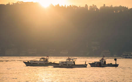 Men on a boat in Bosphorus waters in Istanbul. Fisherman in boat in Istanbul. Turkish fisherman sailing in boat in sea.の写真素材