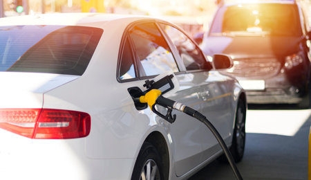 Refuel cars at the fuel pump. The driver hands, refuel and pump the car's gasoline with fuel at the...