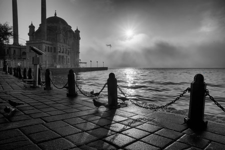 Ortakoy Mosque and Bosphorus Bridge in Istanbul, Turkey. dramatic sky. The 15 July Martyrs Bridge in a fogの写真素材