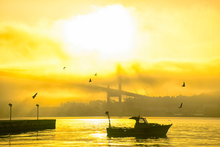 Ortakoy Mosque and Bosphorus Bridge in Istanbul, Turkey. Dramatic sky. The 15 July Martyrs Bridge in a fog. Spectacular Istanbul view in the fog.の写真素材