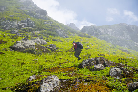 Young man climbing to the top of the mountain in a foggy environment..の写真素材
